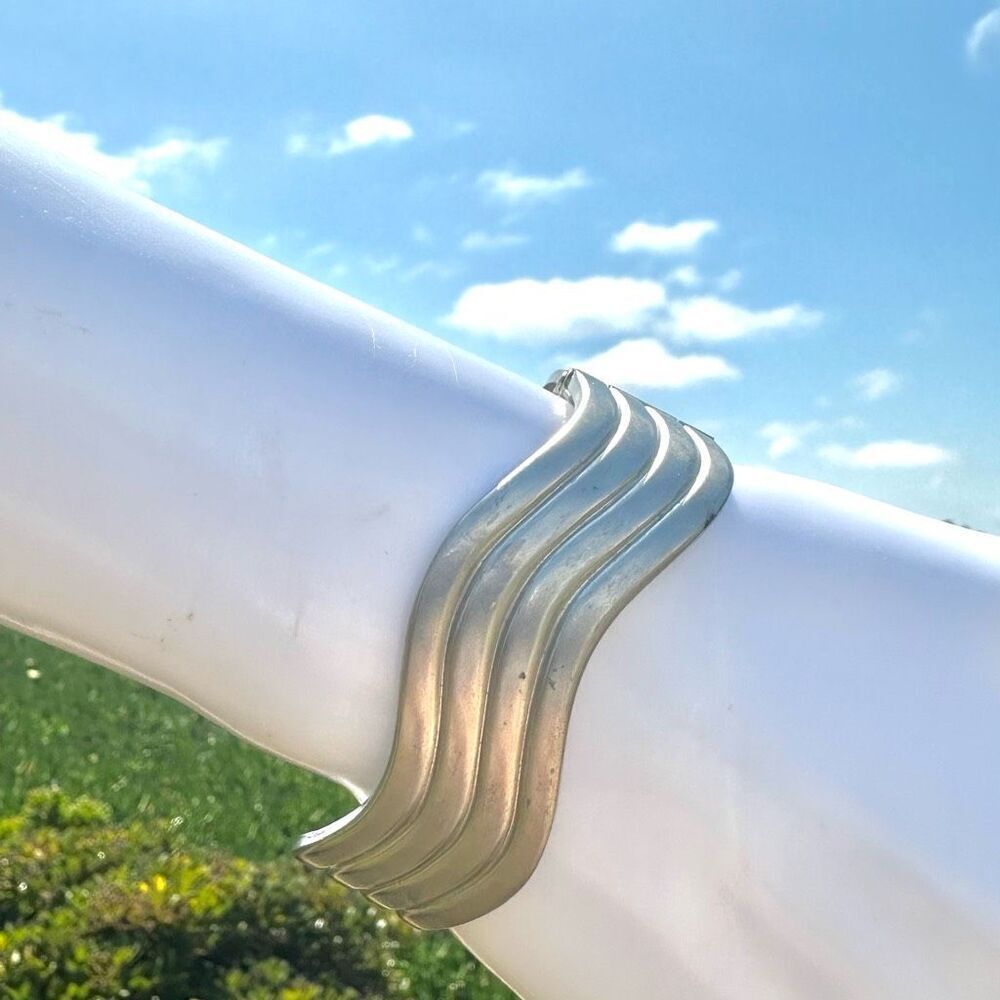 Silver tone modern swirl hinged bracelet
